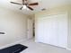 Neutral bedroom with a ceiling fan, a closet, and a door leading to the hallway at 18109 Kara Ct, Tampa, FL 33647
