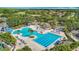 Aerial view of the community pool with seating, splash pad and water slide surrounded by trees at 18109 Kara Ct, Tampa, FL 33647