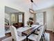 Elegant dining area with a rustic wood table, upholstered chairs, and modern chandelier at 18109 Kara Ct, Tampa, FL 33647