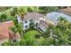 Beautiful two-story home with well-manicured lawn, mature trees, and lush tropical landscaping at 18109 Kara Ct, Tampa, FL 33647
