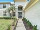 Elegant front entrance with double doors, beautiful landscaping, and plenty of natural light at 18109 Kara Ct, Tampa, FL 33647