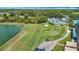 Scenic aerial view of golf course, pool, and tennis courts next to a shimmering lake at 18109 Kara Ct, Tampa, FL 33647