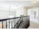 Bright hallway features neutral carpet, dark wood banister, and chandelier views to the front door at 18109 Kara Ct, Tampa, FL 33647