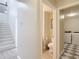 Hallway with stairs leading to an upper floor and a view into a half-bathroom and laundry room at 18109 Kara Ct, Tampa, FL 33647