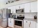 Contemporary kitchen boasting stainless steel appliances, granite countertops, and white cabinets at 18109 Kara Ct, Tampa, FL 33647