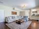 Open concept living room with hardwood floors, chandelier, and comfortable sectional sofa with view to kitchen at 18109 Kara Ct, Tampa, FL 33647