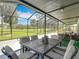 Screened-in patio with an outdoor dining table and comfortable seating area overlooking the golf course at 18109 Kara Ct, Tampa, FL 33647
