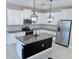 Contemporary kitchen featuring stainless steel appliances, island, granite countertops, white cabinets and decorative backsplash at 18875 Noble Caspian Dr, Lutz, FL 33558