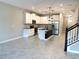 Open-concept kitchen with stainless steel appliances, center island, granite counters, and bright, modern finishes at 18875 Noble Caspian Dr, Lutz, FL 33558