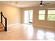 Spacious living area featuring tile flooring, large windows with sliding glass doors and stairway with dark wood railing at 18875 Noble Caspian Dr, Lutz, FL 33558