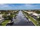 Aerial view of a tranquil canal lined with homes, docks, and lush greenery in a waterfront community at 260 Coronado Dr, Punta Gorda, FL 33950