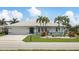 Charming single-story home with well-manicured lawn, white tile roof, and tropical landscaping with palm trees at 260 Coronado Dr, Punta Gorda, FL 33950