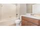 Standard bathroom with white tiled shower-tub, toilet, and wooden vanity cabinet at 11621 Ashton Field Ave, Riverview, FL 33579