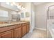 Bright bathroom with dual vanity, granite counters, soaking tub, and glass shower at 11621 Ashton Field Ave, Riverview, FL 33579