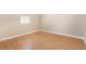 A compact, minimalist bedroom with wood floors, a small window and neutral paint at 11621 Ashton Field Ave, Riverview, FL 33579