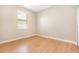 A simple bedroom design featuring wood laminate flooring and a single window at 11621 Ashton Field Ave, Riverview, FL 33579