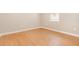 An empty room with hardwood floors and natural light from the window at 11621 Ashton Field Ave, Riverview, FL 33579