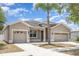 Exterior view of neutral home with two-car garage and desert landscaping at 11621 Ashton Field Ave, Riverview, FL 33579