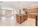 Modern kitchen with a center island, stainless steel appliances, and tiled flooring for a sleek design at 11621 Ashton Field Ave, Riverview, FL 33579