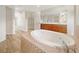 Bright bathroom featuring a soaking tub, dual sinks, and walk-in closet access at 13210 Essman Ave, Port Charlotte, FL 33953