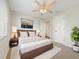 A cozy bedroom features a ceiling fan, warm lighting, and a king bed with a modern wood frame at 13210 Essman Ave, Port Charlotte, FL 33953