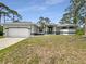 Well-maintained one story home featuring a two-car garage and manicured landscaping at 13210 Essman Ave, Port Charlotte, FL 33953