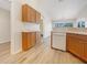 Kitchen featuring wood cabinets and stainless dishwasher plus wood-look floors at 13210 Essman Ave, Port Charlotte, FL 33953