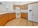 Well-lit kitchen with wood cabinets and modern white appliances on wood-look floors at 13210 Essman Ave, Port Charlotte, FL 33953