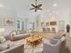 A spacious living room features neutral tones, stylish furnishings, and an open layout to the kitchen at 13210 Essman Ave, Port Charlotte, FL 33953
