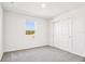 Carpeted bedroom featuring closet and natural light from a single window at 1740 Brekey Way, Zephyrhills, FL 33541