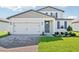 Charming two-story home with manicured lawn, brick driveway, and two-car garage at 1740 Brekey Way, Zephyrhills, FL 33541