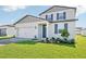 Charming two-story home with a manicured lawn, brick driveway, and blue shutters at 1740 Brekey Way, Zephyrhills, FL 33541