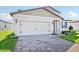Two-story home with a two car garage, brick paver driveway, and well maintained lawn at 1740 Brekey Way, Zephyrhills, FL 33541