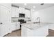 Bright kitchen with white cabinets, granite countertops, stainless steel appliances, and island at 1740 Brekey Way, Zephyrhills, FL 33541