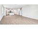 Open-concept living room with wood-style tile flooring seamlessly connects to the modern kitchen at 1740 Brekey Way, Zephyrhills, FL 33541