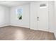 Bright living room featuring tile flooring, a window view, and a white front door at 1740 Brekey Way, Zephyrhills, FL 33541