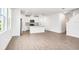 Sunlit living area flows into a modern kitchen with stainless steel appliances and white cabinetry at 1740 Brekey Way, Zephyrhills, FL 33541