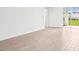 Bright, spacious living room featuring wood-look tile flooring and sliding glass door to back patio at 1740 Brekey Way, Zephyrhills, FL 33541