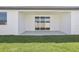 Covered back porch with sliding glass doors and a view of the green backyard at 1799 Draughton Dr, Zephyrhills, FL 33541