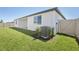 View of the backyard featuring a lush lawn and a white vinyl fence for privacy at 1799 Draughton Dr, Zephyrhills, FL 33541