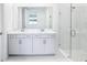 Modern bathroom with double vanity, frameless glass shower, white marble-style tile, and clean, bright design at 1799 Draughton Dr, Zephyrhills, FL 33541