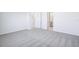 Spacious bedroom with plush gray carpet, neutral walls, ample natural light, and ensuite bathroom access at 1799 Draughton Dr, Zephyrhills, FL 33541