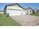 Charming home featuring a three-car garage, well-manicured lawn, and beautiful landscaping at 1799 Draughton Dr, Zephyrhills, FL 33541