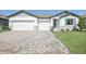 Charming single-Gathering home with brick paved driveway, three-car garage, manicured lawn, and a welcoming entryway at 1799 Draughton Dr, Zephyrhills, FL 33541