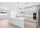 Contemporary kitchen with white cabinets, stainless steel appliances, a central island, pendant lights, and light wood flooring at 1799 Draughton Dr, Zephyrhills, FL 33541