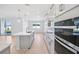 Modern kitchen with island, stainless steel appliances, white cabinetry, and an open layout to the living area at 1799 Draughton Dr, Zephyrhills, FL 33541