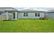 The spacious backyard features lush green grass, a covered patio, and great natural light at 1859 Draughton Dr, Zephyrhills, FL 33541
