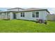 A lush backyard with green grass, a covered patio, and a well-maintained perimeter fence at 1859 Draughton Dr, Zephyrhills, FL 33541