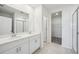 Modern bathroom featuring double sinks, bright lighting, and a glass-enclosed shower at 1859 Draughton Dr, Zephyrhills, FL 33541