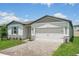 Charming single-story home with a two-car garage, well-manicured lawn, and brick paved driveway at 1859 Draughton Dr, Zephyrhills, FL 33541